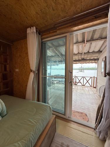 una camera da letto con finestra con vista sull'oceano di Kaneng Homestaykohpu a Ban Klang
