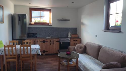 a living room with a couch and a kitchen at Agroturystyka Dzika Łąka apartament 
