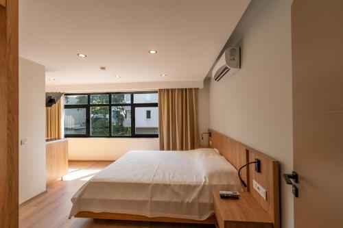 a bedroom with a bed and a large window at Bun'ca Rooms in Antalya