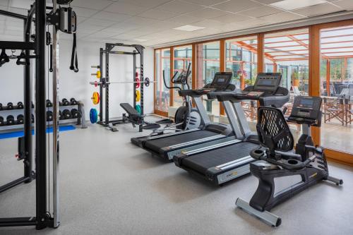 a gym with several treadmills and elliptical machines at Silvanus Hotel in Visegrád
