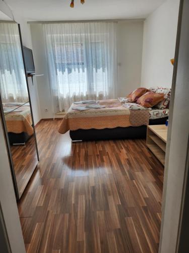 a bedroom with a bed and a wooden floor at Casa Mea Privatzimmer 2 in Klingenbach