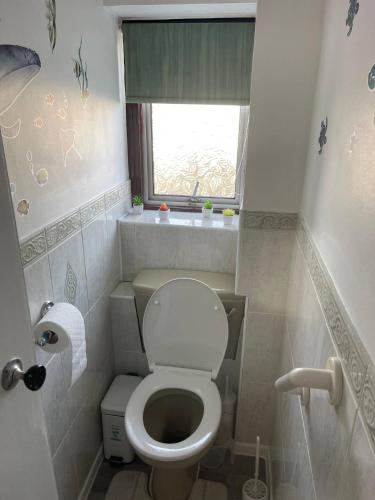 a small bathroom with a toilet and a window at Basildon - Stay 5 - Garden - Parking - Town Centre in Basildon