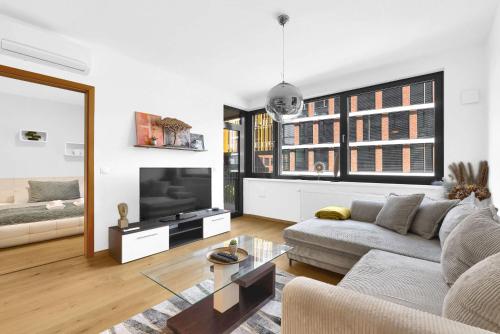 a living room with a couch and a tv at Riverside luxury apartment in Bratislava