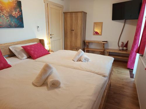 two beds in a hotel room with towels on them at Nonićeva Hiža in Fužine