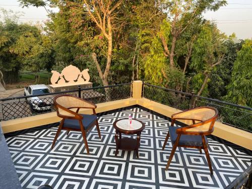 a patio with two chairs and a table on a balcony at CABANA- 5 BHK Luxury Villa near Udaipur in Dabok