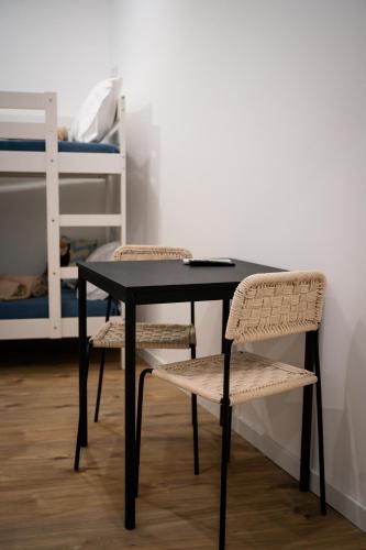 a black table with two chairs and a bed at Riad'a Praia in Armação de Pêra