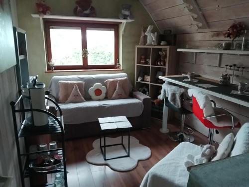 uma sala de estar com um sofá e uma mesa em Chambre cosy em Buhl