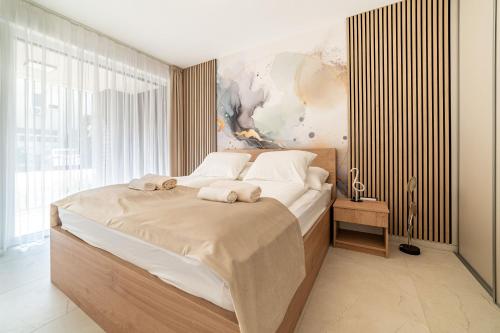a bedroom with a large bed with towels on it at Hajnal Residence Deluxe with Terrace by Mital in Szeged