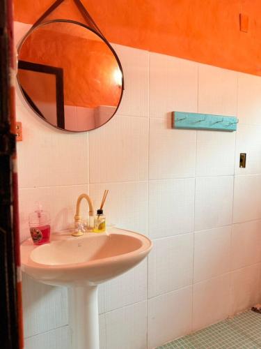a bathroom with a sink and a mirror at Hostel Pantera do Rosa in Praia do Rosa