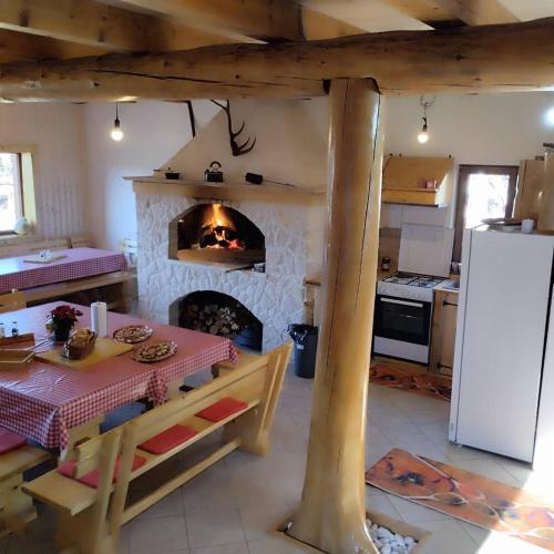 a kitchen with a fireplace and a table with a table sidx sidx sidx at Nonićeva Hiža in Fužine
