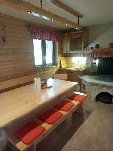 a kitchen with a wooden table and a fireplace at Nonićeva Hiža in Fužine