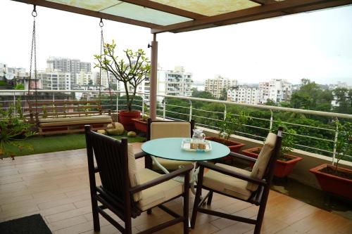 a patio with a table and chairs on a balcony at Chandralok Service Apartments in Kolhapur