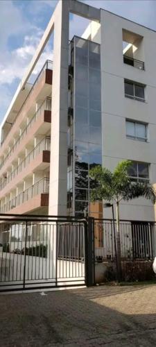 a building with a fence in front of it at Flat Completo in Cotia