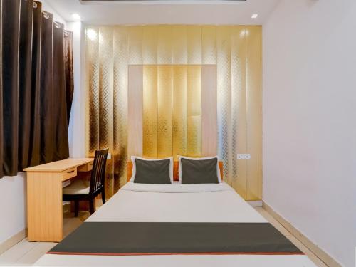 a bedroom with a bed and a desk and a table at Super Collection O Kiara Guest House in Lucknow