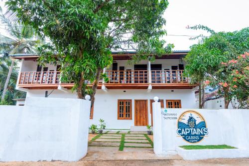 a house with a sign in front of it at Captains Cabins Arugambay in Arugam Bay