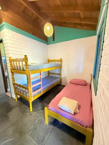 a bedroom with two bunk beds in a room at Hostel Pantera do Rosa in Praia do Rosa
