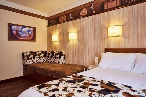 a hotel room with a bed and a chair at Disney Hotel Cheyenne in Coupvray