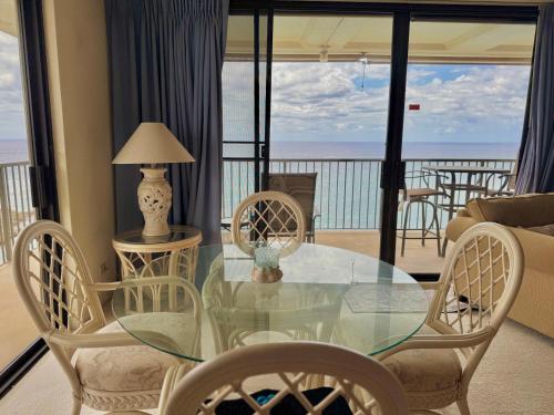 a glass dining room table with chairs and a view of the ocean at #Marbella Lane - Beachfront Haven with MT Views! in Waianae