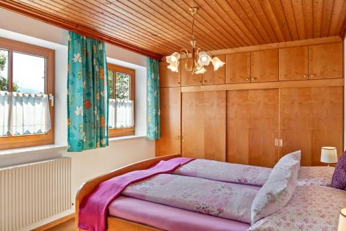 Un dormitorio con una cama y un techo de madera. en Biobergbauernhof Bergzeit Apartment, en Goldegg