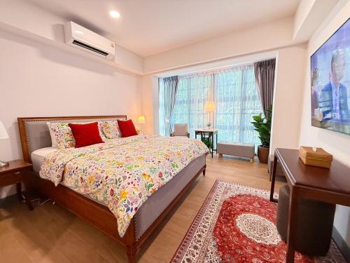 Un dormitorio con una cama y una ventana grande. en Casa Klang Wiang, en Chiang Mai