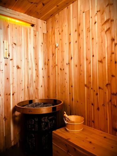 a sauna with a wooden wall with a hot tub at Lava Homes in Santo Amaro
