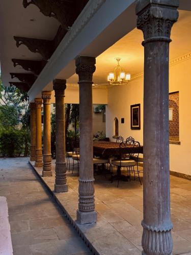 a group of columns in a room with a table at CABANA- 5 BHK Luxury Villa near Udaipur in Dabok