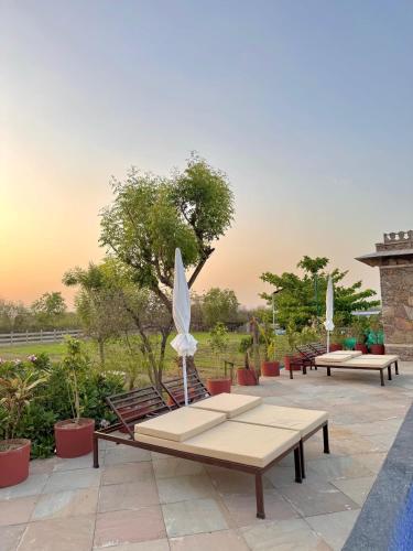 a group of benches with umbrellas on a patio at CABANA- 5 BHK Luxury Villa near Udaipur in Dabok