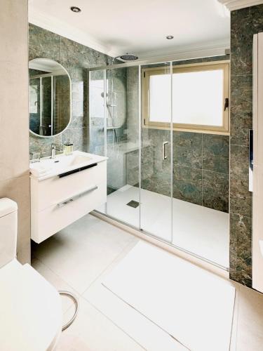 a bathroom with a glass shower and a sink at Elegant 2 Br with parking in Cannes