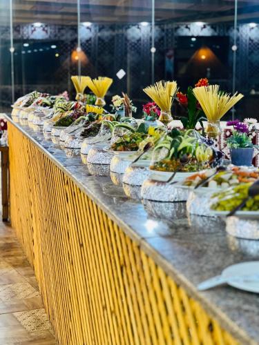 a buffet line with many plates of food at Regency Rum Luxury Camp in Wadi Rum