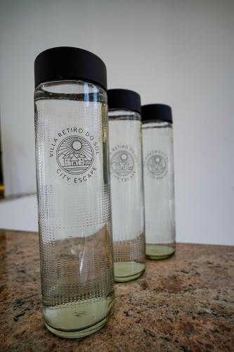a group of three glass bottles sitting on a table at Peaceful Escape in Gurgaon - Villa Retiro Do Sol in Manesar
