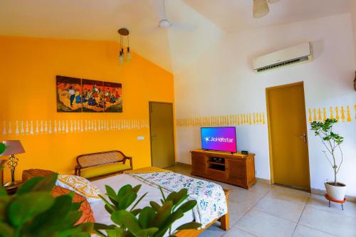 a living room with a bed and a television at Peaceful Escape in Gurgaon - Villa Retiro Do Sol in Manesar