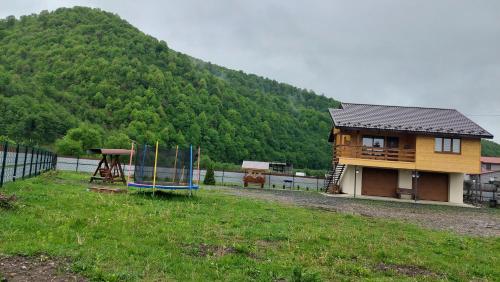 a house with a playground in front of a mountain at Файний будинок in Mizhhirʼʼya