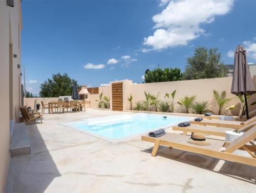a backyard with a swimming pool and patio furniture at Roots Villa in Skinés