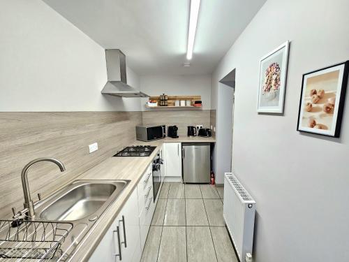 a kitchen with a sink and a counter top at Warm & Cosy Home in Glasgow in Glasgow