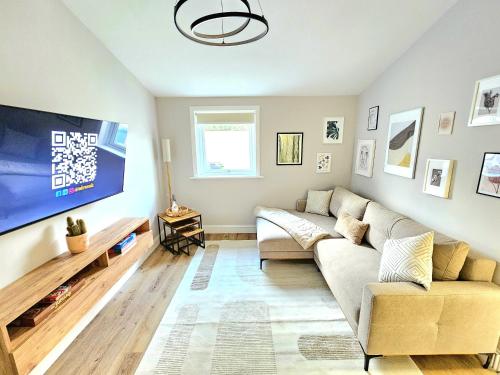 a living room with a couch and a tv at Warm & Cosy Home in Glasgow in Glasgow