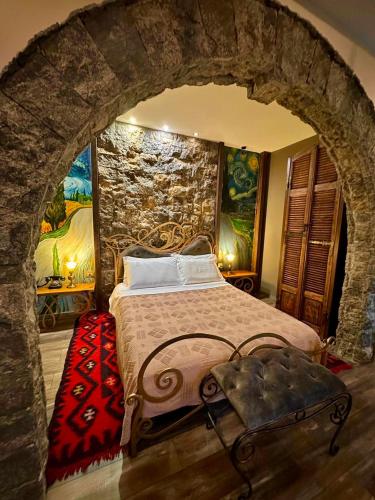 a bedroom with a large bed in a stone wall at Vila Eden Boutique Hotel in Korçë