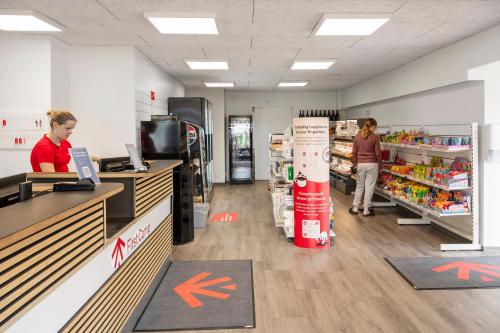 a store with two women standing in a store aisle at First Camp Skovlund Camping & Cottages in Båring