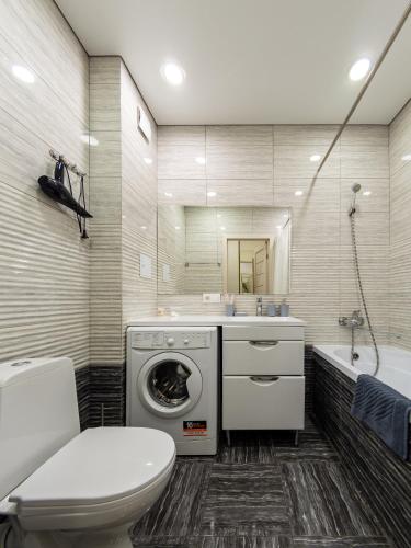 a bathroom with a washing machine and a toilet at Апартамент на Тулебаева! in Almaty