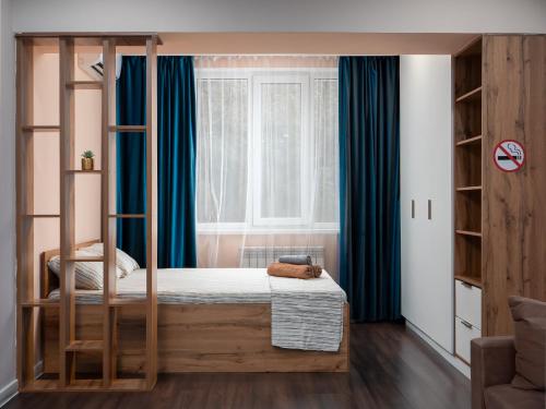 a bedroom with a wooden bunk bed with blue curtains at Апартамент на Тулебаева! in Zhezdi