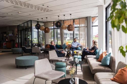a group of people sitting on couches in a lobby at ArenaHotellet i Uppsala in Uppsala