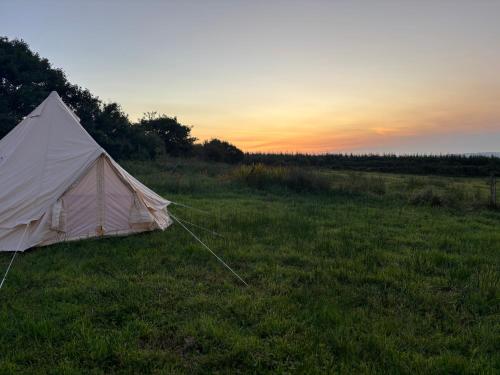 a white tent in a field at sunset at Little Reds Seaview Cottage in Liscannor