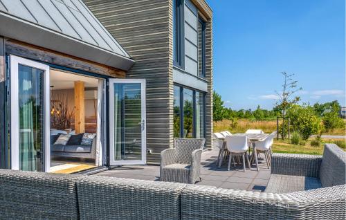 Un patio con sillas y mesas de mimbre en un patio. en 4 Bedroom Stunning Home In Kamperland, en Kamperland