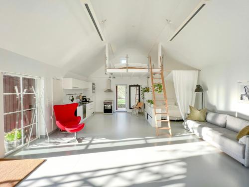 a living room with a couch and a red chair at Lovely "Studio Solbakke" At Asmaløy, Hvaler in Rød