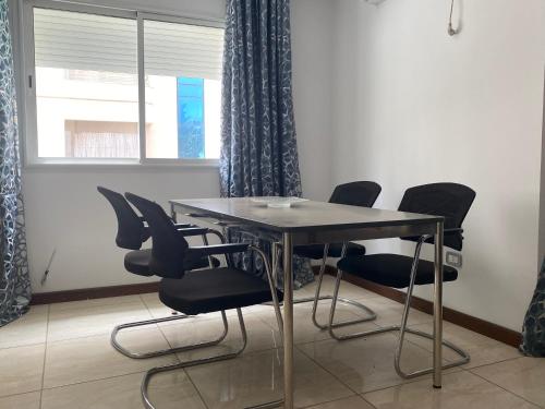 a table and chairs in a room with a window at Appartement lumineux et moderne in Sidi Daoud