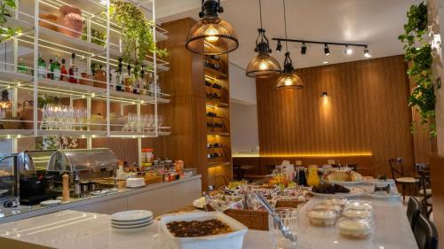 a restaurant with a counter with dishes on it at Zallon Hotel Executivo in Lajeado