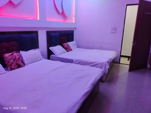 two beds in a room with white sheets at Shyam Krapa Hotel in Rīngas