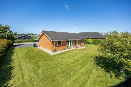 a house with a large lawn in front of it at Holiday house Løgten Tversted in Bindslev