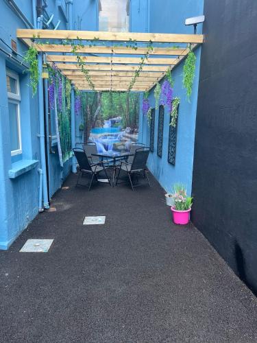 a patio with a table and chairs under a pergola at The C Den Amazing Seaview, ground floor, free wifi & parking in Whitehead