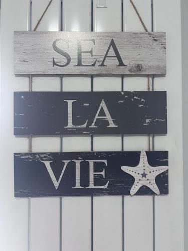 a sign that says sea la vie on a building at The C Den Amazing Seaview, ground floor, free wifi & parking in Whitehead