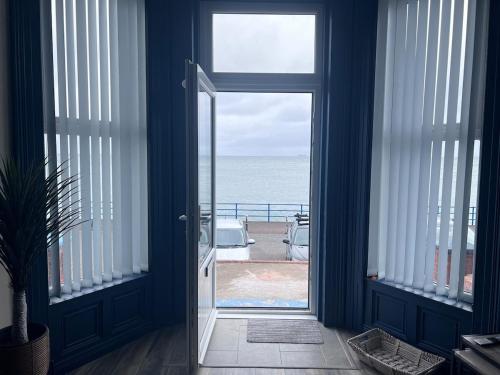 an open door with a view of the ocean at The C Den Amazing Seaview, ground floor, free wifi & parking in Whitehead